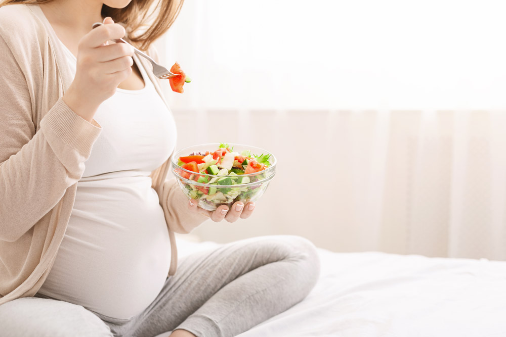 kobieta w ciąży je zdrowy posiłek na diecie